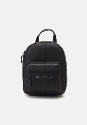 Black leather backpack with rounded shape, featuring a front zip pocket, embossed logo, and a top handle for carrying.