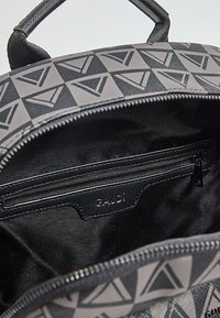 Zaino nero con motivo geometrico grigio, materiale in tessuto, apertura con cerniera e piccola tasca interna con chiusura a zip.