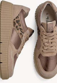 Sneakers con una parte superiore in suede beige chiaro, dettagli metallici marroni e un pannello con stampa leopardata. Presentano una chiusura con lacci e una suola in gomma rigata.