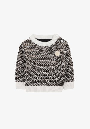 Pull en tricot avec un motif texturé en noir et crème, présentant un col et des poignets côtelés blancs, ainsi qu'un logo rond.