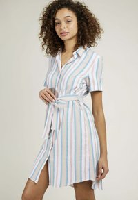Robe chemise rayée en tissu léger, dotée de manches courtes, d'une fermeture à boutons à l'avant, d'une ceinture à la taille et de rayures verticales dans des couleurs pastel avec des détails subtils.