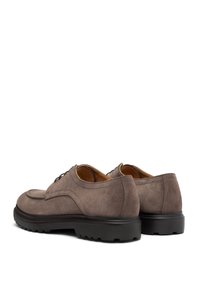 Pantofi din suede gri cu vârful rotund, căptușeală din piele și o talpă groasă din cauciuc negru. Prezintă detalii cusute și șireturi plate.