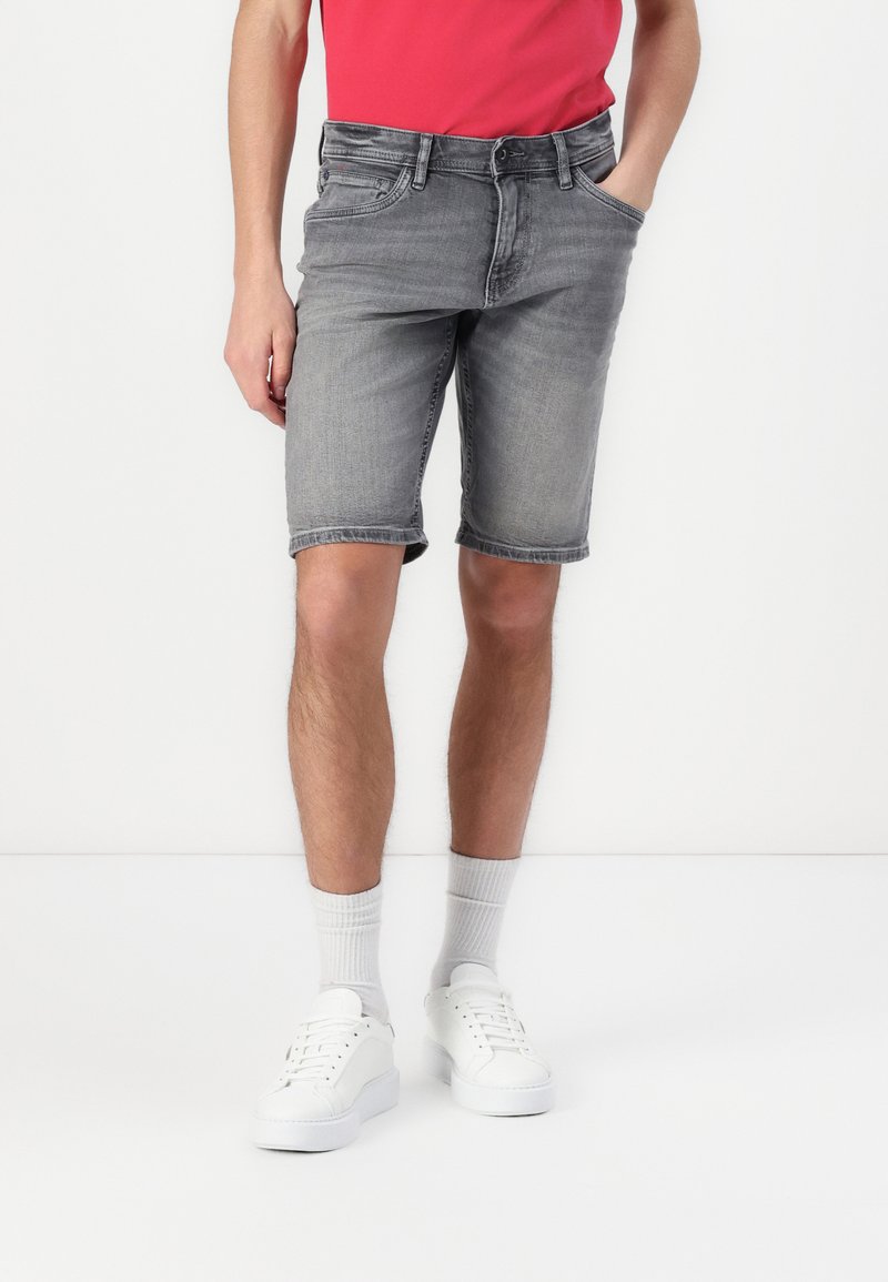 Shorts en denim gris avec une coupe régulière, design à cinq poches et ourlets retroussés, associés à des baskets blanches et des chaussettes grises.