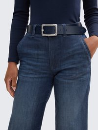 Námornícky dlhý rukáv spárovaný s tmavomodrými denimovými nohavicami. Čierny opasok s obdĺžnikovou striebornou prackou, 2 viditeľné vrecká a štruktúrovaná tkanina.