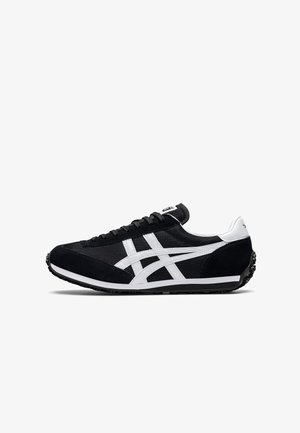 Black athletic shoe with mesh and suede material, featuring white accents and three stripes on the side. Flat rubber sole with textured grip.