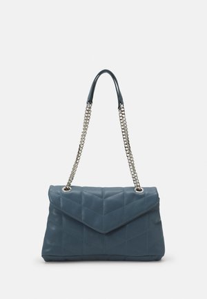 Sac à main en cuir bleu matelassé avec rabat à rabat, bandoulières en chaîne argentée et motif géométrique sur la surface.