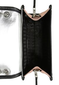 Musta ja hopea käsilaukku tyylikkäällä muotoilulla, jossa on metallinen ulkopinta, vaaleanpunainen vuori ja teksturoitu musta sisustus. Hopeiset yksityiskohdat.