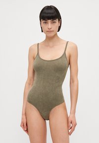 Maillot de bain côtelé vert olive avec des bretelles fines, doté d'un décolleté dégagé et d'une texture lisse et ajustée.