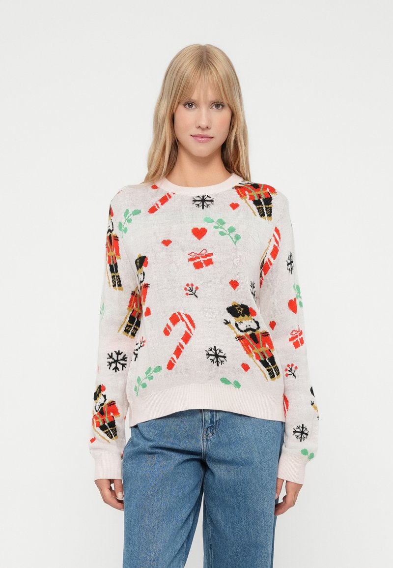 Pullover mit einem hellrosa Hintergrund, verziert mit festlichen Motiven wie einem Nussknacker, Zuckerstangen, Geschenken und Herzen. Hergestellt aus weichem, gewebtem Material.