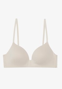 Beige színű, vezeték nélküli melltartó sima, formázott kosarakkal. Vékony, állítható pántokkal és egyszerű hátsó zárással rendelkezik. Puha anyagból készült.