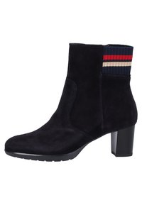 Bota de tobillo de ante negro con tacón cuadrado, puño de canalé en navy con rayas rojas y beige, y panel elástico lateral para facilitar el uso.