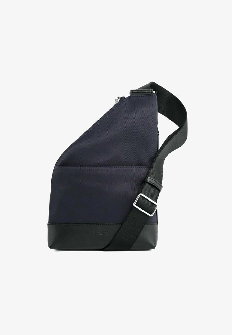 Borsa a spalla in tessuto blu navy con design angolare, base in pelle nera a contrasto, tracolla regolabile e chiusura con zip in tonalità argento.