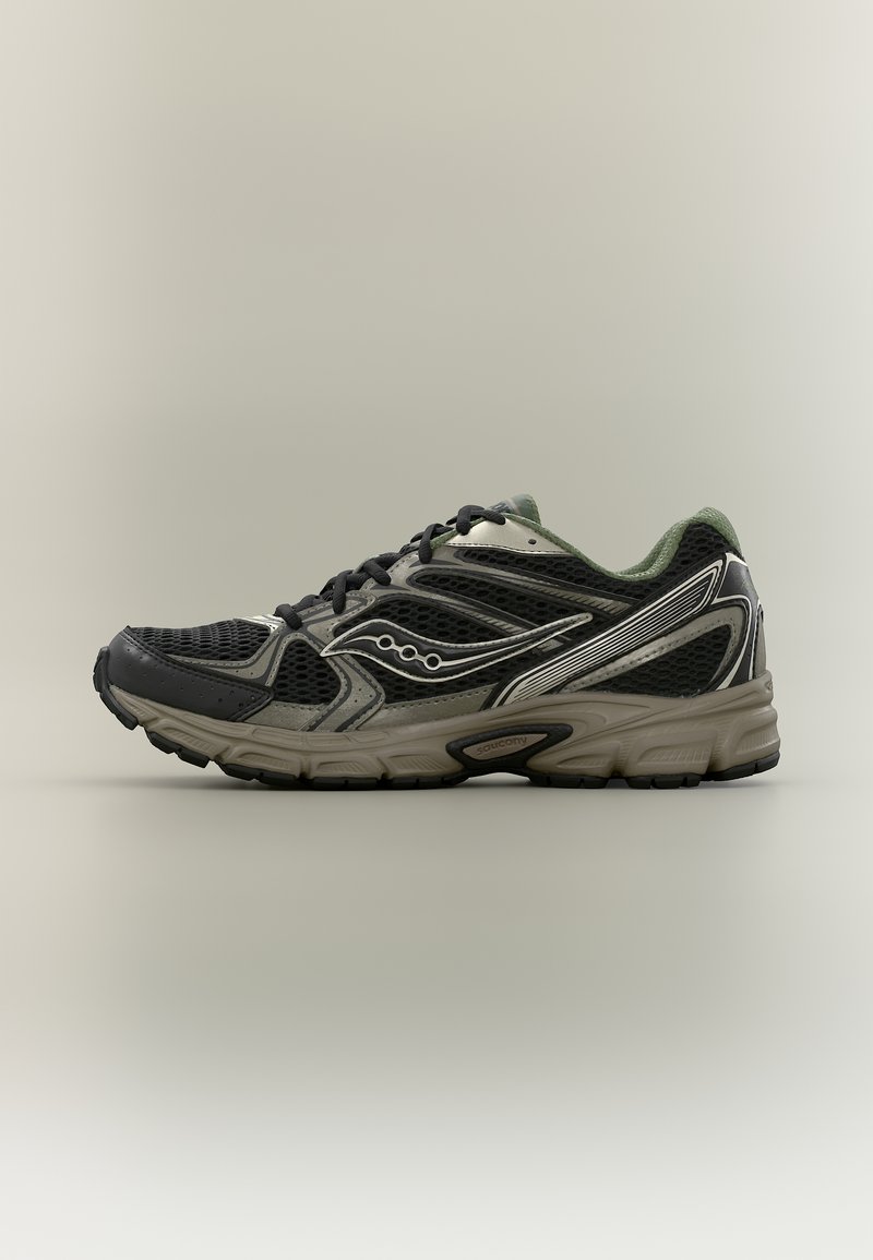 Μαύρο και γκρι δίχτυ αθλητικό παπούτσι με μπεζ σόλα, μαύρα κορδόνια και λευκές λεπτομέρειες, εμφανιζόμενο από τη πλευρά σε ουδέτερο φόντο.