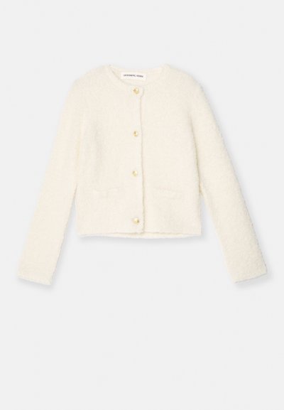 Weißer, flauschiger Cardigan mit langen Ärmeln, goldenen Knöpfen und zwei Fronttaschen. Weicher Stoff und kurz geschnittenes Design.