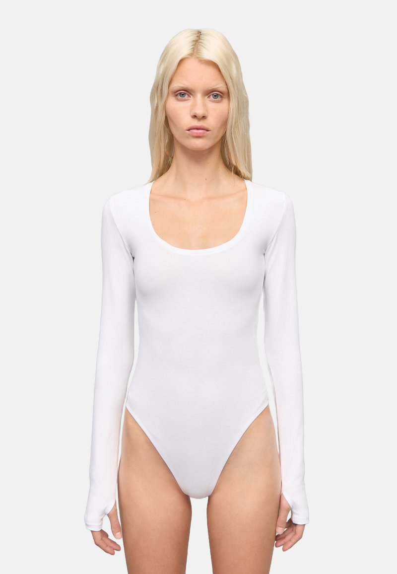 Body de manga larga blanco con escote en forma de U, hecho de un tejido liso y elástico. Presenta un diseño ajustado y aberturas de pierna de corte alto.
