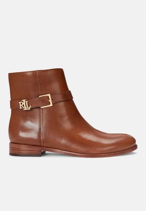 Brown leather ankle boot with a smooth texture, gold-tone buckle detail, flat wooden heel, and streamlined design.