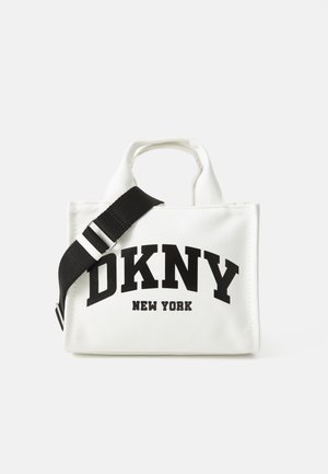 Saco de tela branco com o logo preto "DKNY NEW YORK", alças curtas, faixa ajustável preta, forma retangular, material texturizado.