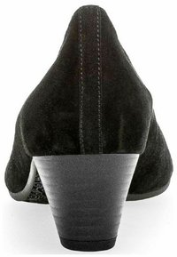 Black suede pump with a rounded toe, low stacked heel, and visible stitching along the back, featuring a textured inner lining.