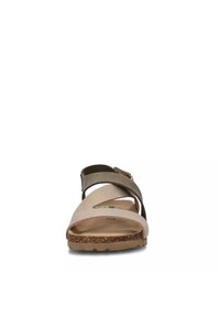 Sandalo marrone e beige con suola in sughero, due cinghie, punta aperta arrotondata e design ritagliato sulla tomaia. Fibbia regolabile alla caviglia.