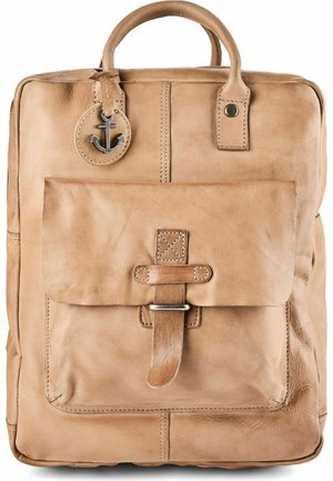 Mochila de cuero marrón claro con bolsillo delantero asegurado con correa y charm metálico en forma de ancla colgando del asa superior.