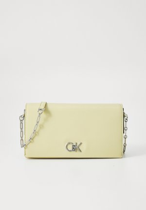 Yellow leather handbag with a smooth texture, featuring a silver chain strap and a metallic logo accent on the front.