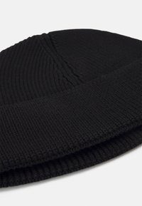 Zwarte gebreide beanie met ribbelstructuur, met een snug fit en een omgevouwen rand. Gemaakt van zacht, rekbaar materiaal.