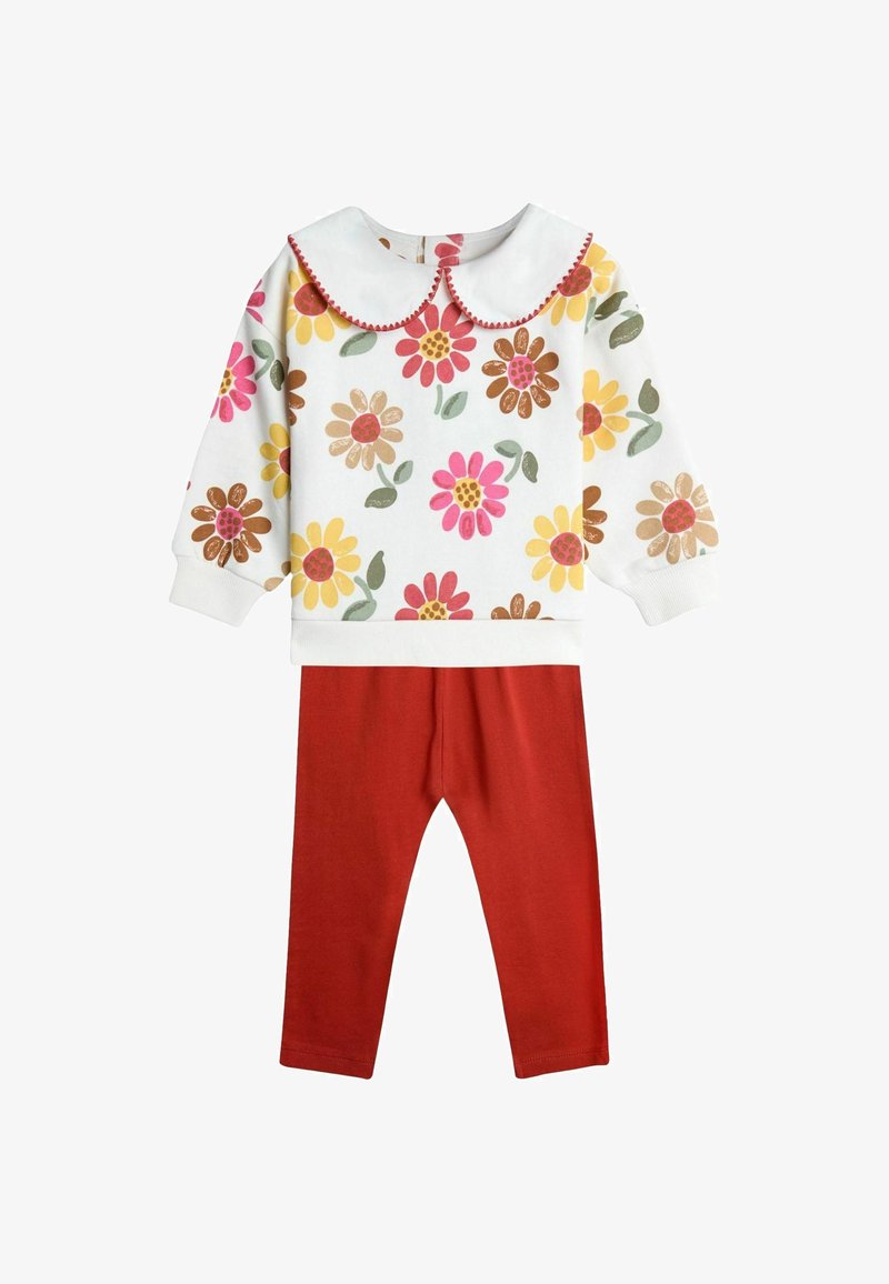 Sweat-shirt blanc à motifs floraux avec col rond et finitions rouges, associé à un legging rouge uni, le tout en tissu coton doux.