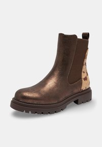 Bottines métalliques marron avec une tige en cuir texturé, des panneaux latéraux élastiques et un accent en peau de vache à motif au niveau du talon. Semelle épaisse.