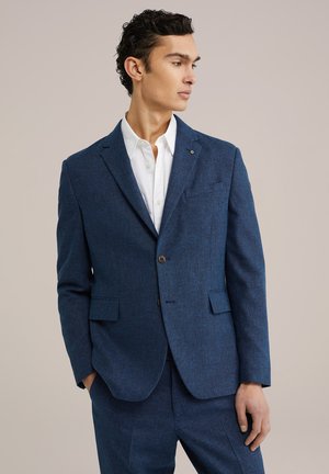 Dark blue blazer with a textured fabric, single button closure, front pockets, and notch lapels. Paired with a white collared shirt.