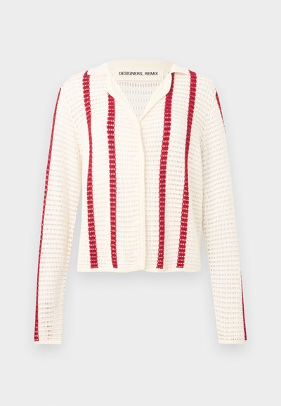Κρεμ πλεκτή ζακέτα με κάθετες κόκκινες ρίγες, μακριά μανίκια, κουμπιά μπροστά και υφή ανοιχτής πλέξης.