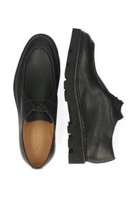 Scarpe in pelle nera con finitura liscia, punta arrotondata, design con lacci e suola in gomma robusta. Cuciture minimaliste lungo i bordi.