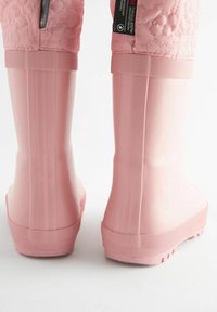 Botas de goma rosa impermeables con un patrón floral texturizado por encima del tobillo, lados acanalados y una suela plana antideslizante.