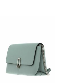 Sac à main en cuir vert menthe clair avec une fermeture à rabat, des ferrures argentées et une bandoulière chaîne. Texture lisse ; forme structurée avec des bords arrondis.