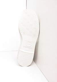 Semelle en caoutchouc blanc avec motif de bande de roulement ondulé et logo "BENSIMON" en relief. Forme ronde avec une texture lisse et propre sans défauts visibles.