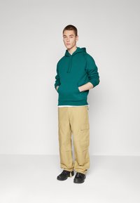 Carhartt WIP HOODED CHASE - Jersey con capucha - chervil/gold