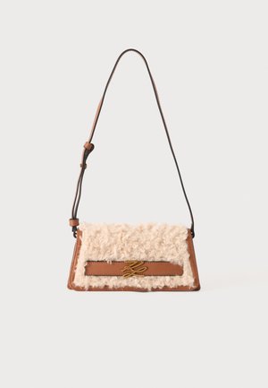 Sac à main en cuir marron avec devant en shearling bouclé couleur crème, fermoir décoratif doré et bandoulière ajustable.