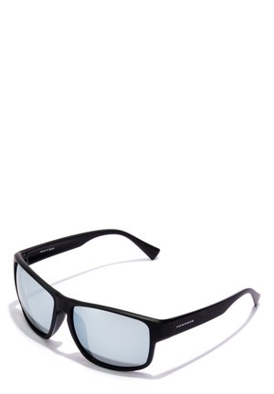 Juodos plastikinės saulės akinių su poliarizuotais šviesiai mėlynais lęšiais, plačia stačiakampio forma ir subtiliu logotipo detaliu ant šventyklų. Pagaminta Ispanijoje.