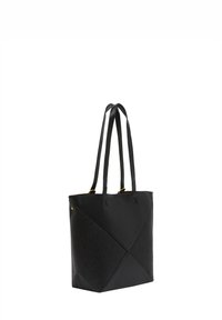 Sort tote taske med dobbeltremme, der har en tekstureret overflade og geometrisk paneldesign. Guld hardware detaljer nær toppen.