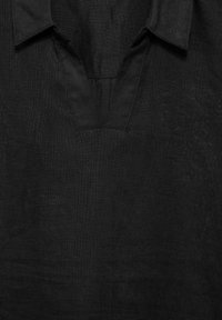 Schwarze Leinenbluse mit umschlagbarem Kragen und V-Ausschnitt, aus strukturiertem Stoff mit dezenten Stickdetails.