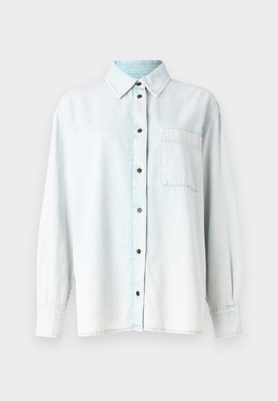 Chemisă din denim de culoare albastru deschis, cu mâneci lungi, guler ascuțit, închidere cu butoane în față, un buzunar pe piept și butoane maro. Textură moale, spălare ușor decolorată.