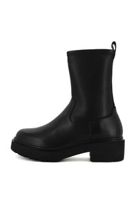 Stivaletto in pelle nera con finitura liscia, punta tonda, suola piatta e linguetta sul retro. Caratterizzato da pannelli elastici laterali per una facile vestibilità.