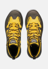 Chaussures de randonnée jaunes et noires avec une tige en mesh, un embout texturé, un col rembourré, et des lacets contrastants pour un maintien sûr et un bon soutien.