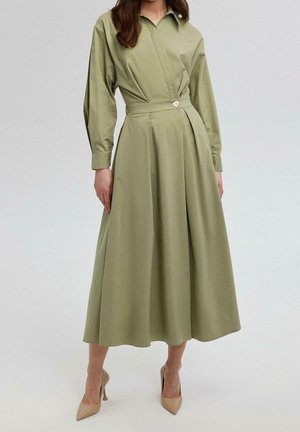 Robe midi kaki à manches longues, col, plis à la taille et détail boutons. En coton, texture lisse, forme ample et fluide.