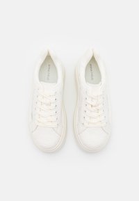 Vita sneakers med texturerad snörning, rund tå, sex hål för snörning och vadderad sula. Varumärket tryckt inuti.