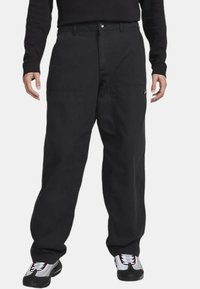 Mustat cargo-housut suoralla lahkeella, valmistettu kestävästä kankaasta, jossa on kaksi etutaskua ja pieni logo sivussa.