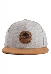 Grijze pet met een gestructureerd stoffen lichaam en een bruin suede klep. Voorzien van een ronde bruine leren patch met zwarte tekst. Zes panelen ontwerp.