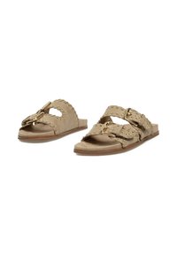 Sandalias deslizantes de ante marrón con correas de doble hebilla, bordes ondulados y acentos de tachuelas en tono dorado; suela plana con un diseño minimalista.