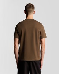 Hnedé bavlnené tričko s krátkymi rukávmi a okrúhlym výstrihom, zobrazené zozadu. Hladká textúra, minimalistický dizajn, bez vzorov.