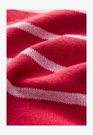 Tessuto lavorato a maglia con una texture ondulata, caratterizzato da ampie righe rosse e sottili righe bianche. Il materiale appare morbido e flessibile.