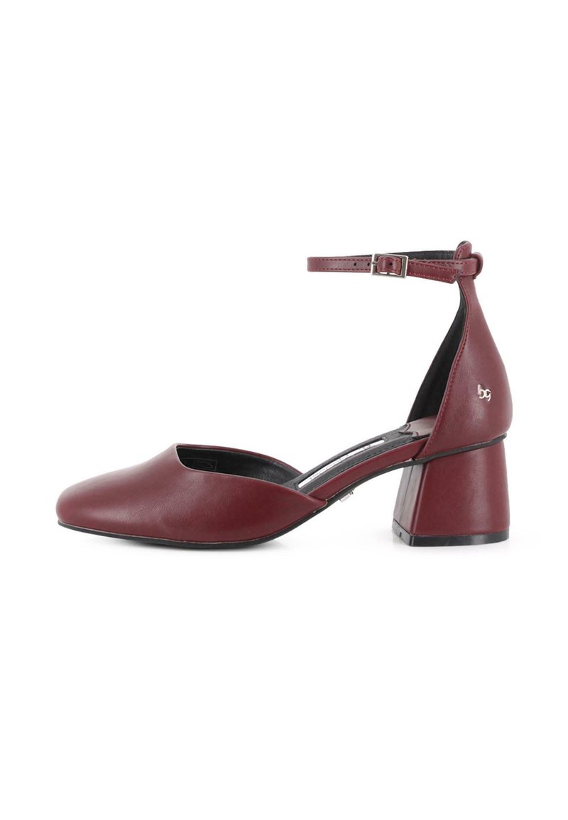 Zapato de tacón cuadrado para mujer en cuero burdeos con tira en el tobillo y hebilla plateada, punta afilada y laterales bajos.